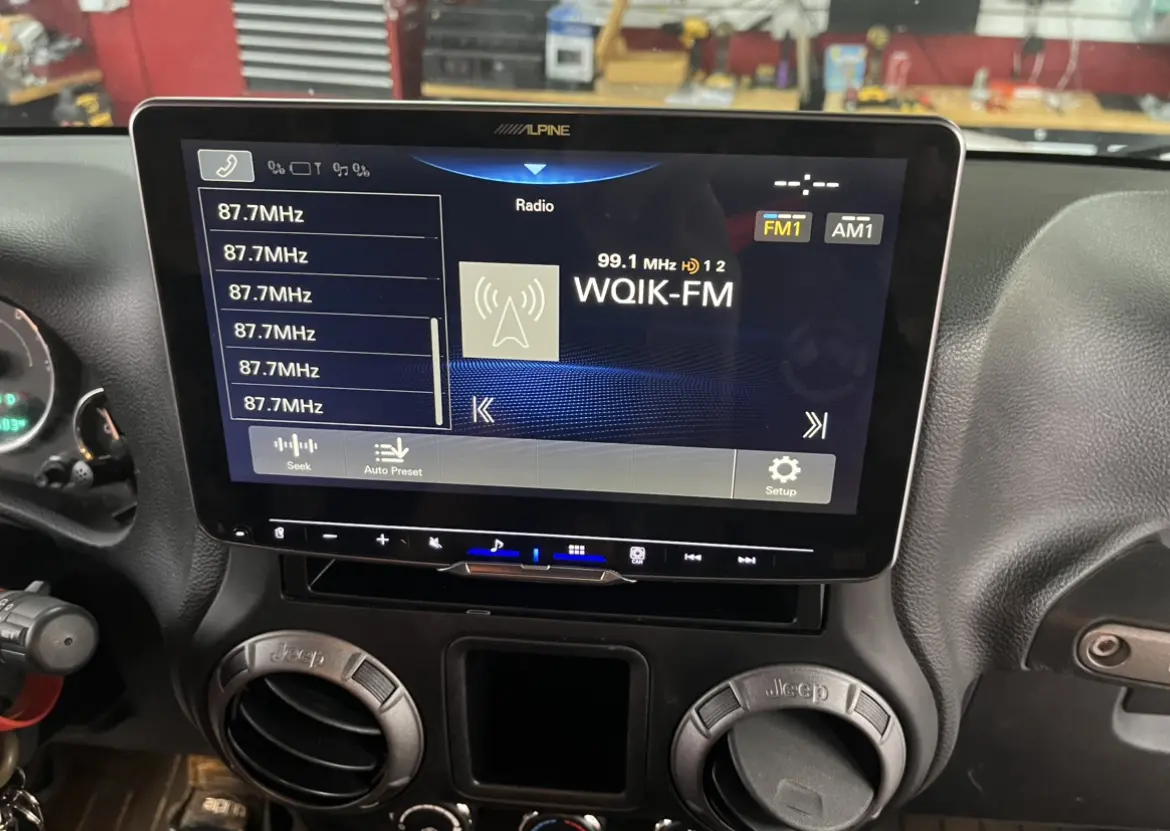A car stereo with the radio playing.