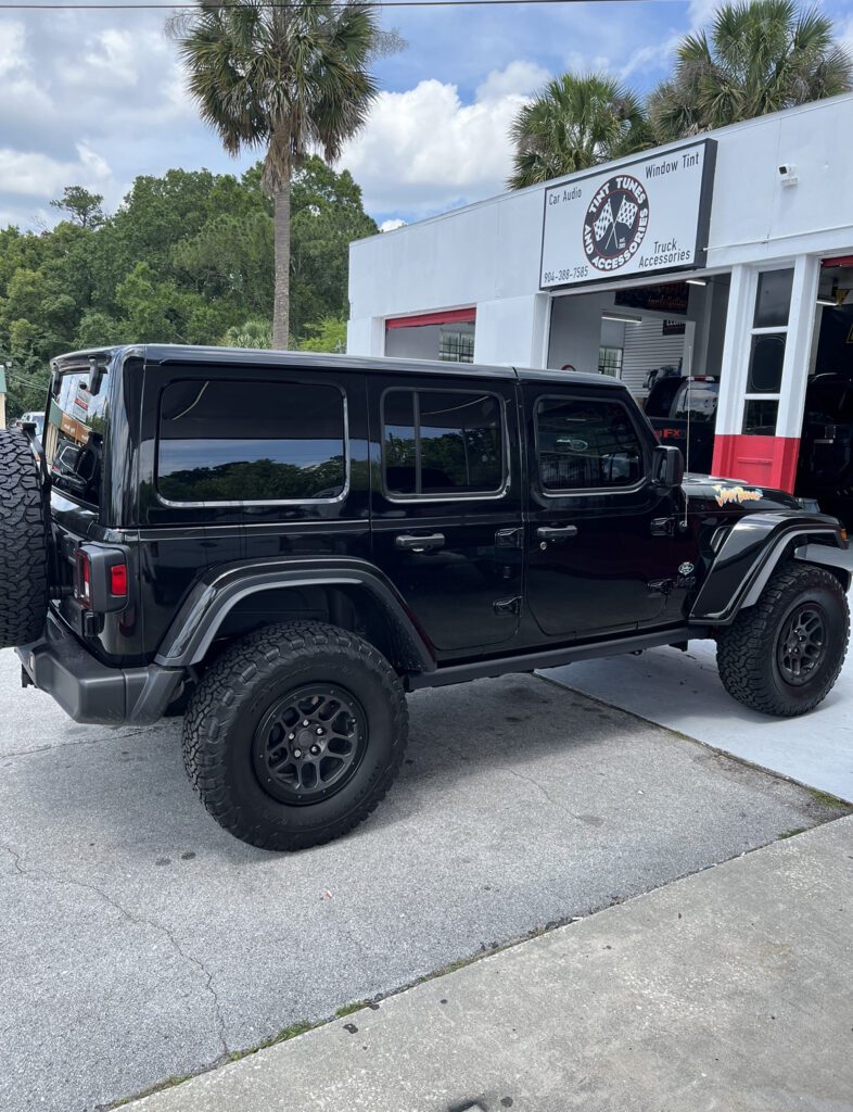 A black jeep parked in front of a building.
